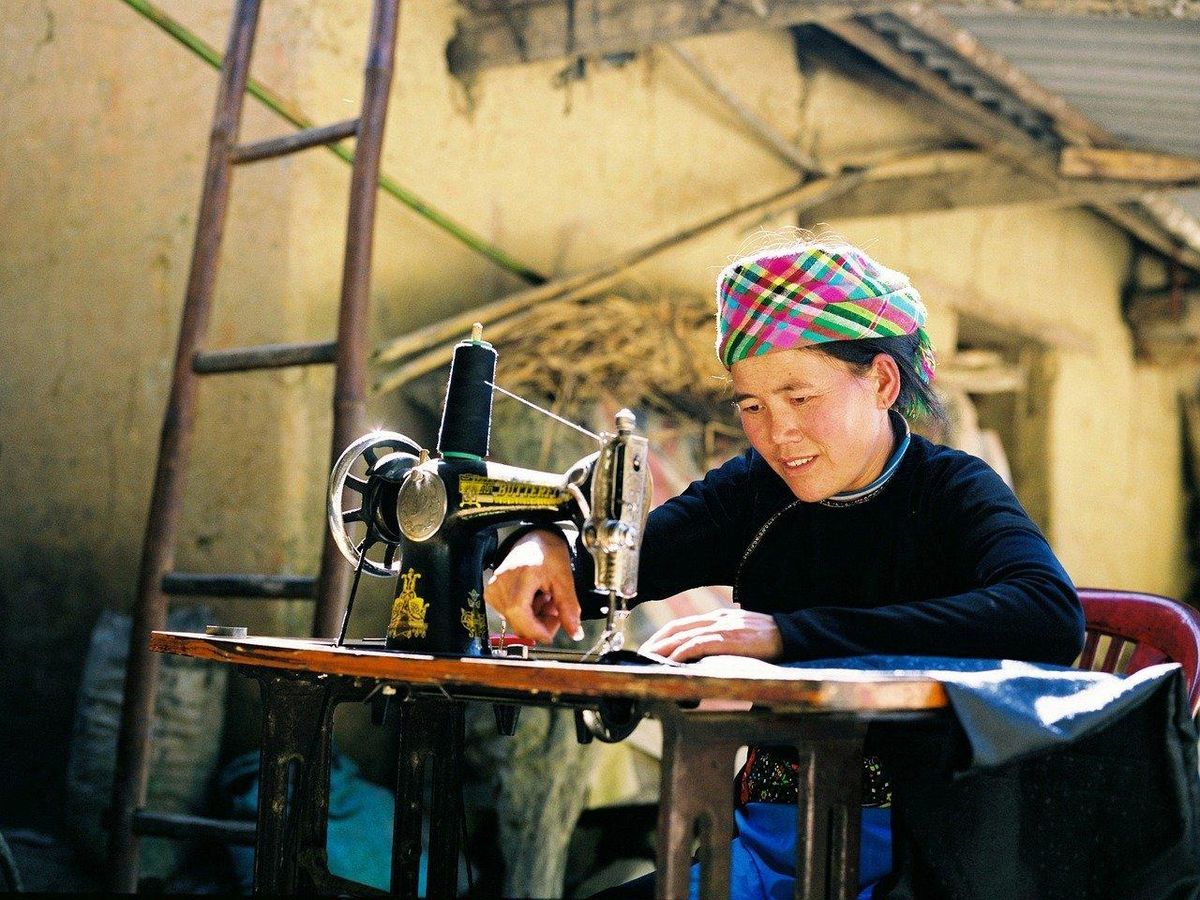 Artisane concentrée, cousant une écharpe avec soin : un savoir-faire incontournable du DIY.