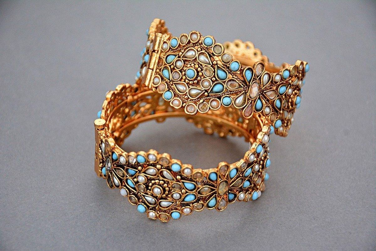Bracelets dorés ornés de pierres azur, le pouvoir d'élégance à chaque poignet.