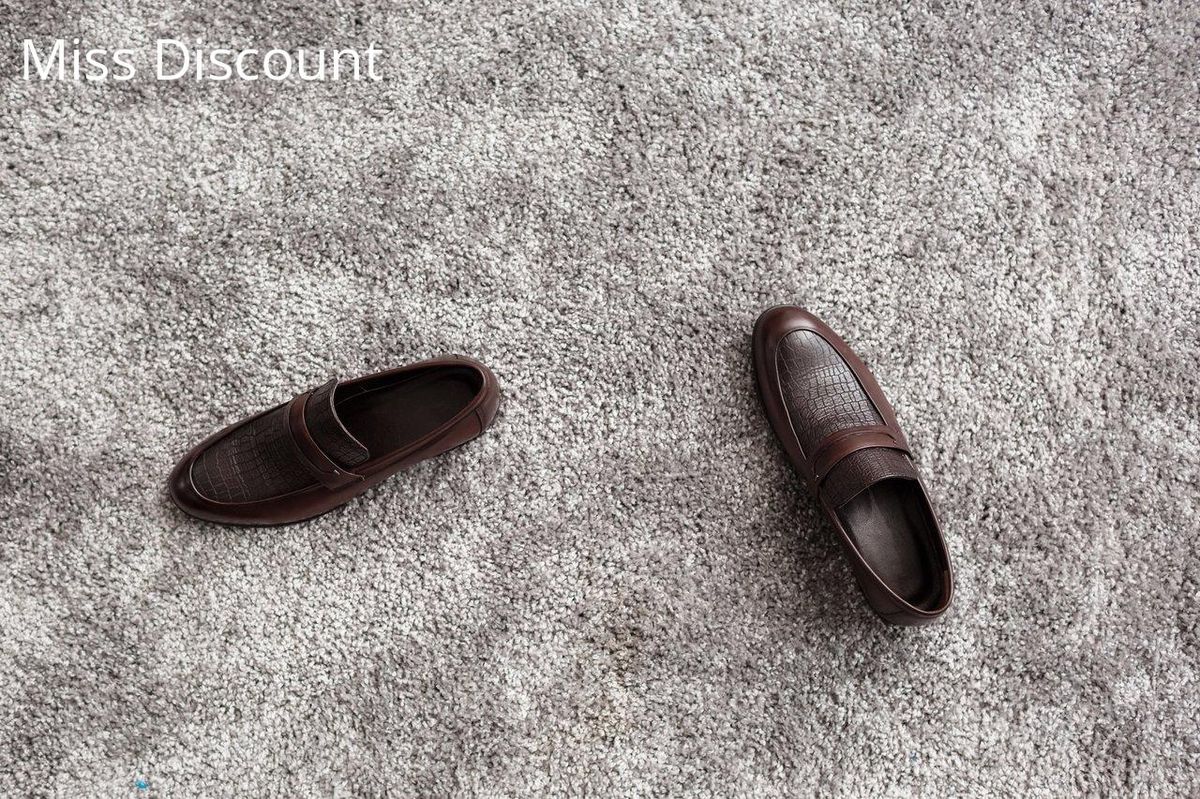 Mocassins en cuir marron sur tapis, alliant élégance et confort pour un style de bureau chic.